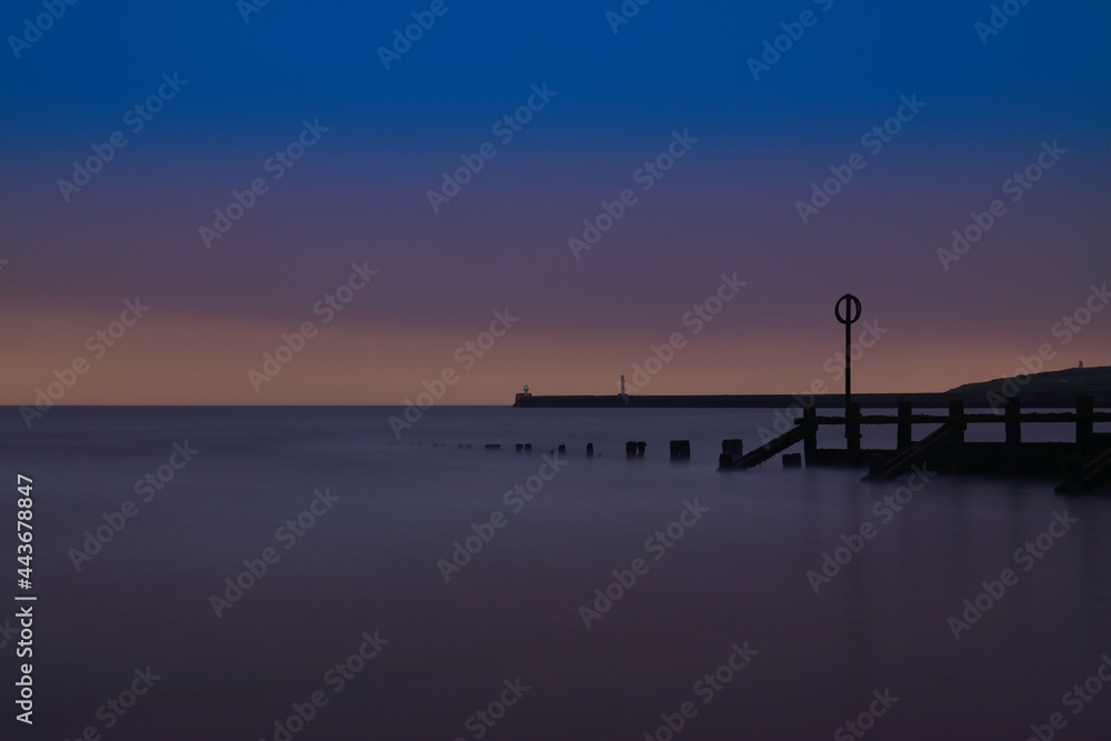 Long Exposure of Aberdeen Beach with lighthouse and breakwater pier. located in Aberdeenshire, Scotland.