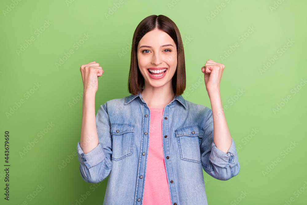 Photo of young girl happy positive smile rejoice win victory lucky success isolated over green color background Photo of young girl happy positive smile rejoice win victory lucky success isolated over green color background