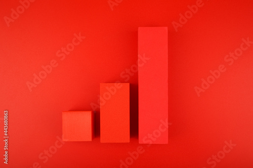 Top view of increasing chart made of red blocks on red background. Concept of business, sales and increasing dynamics