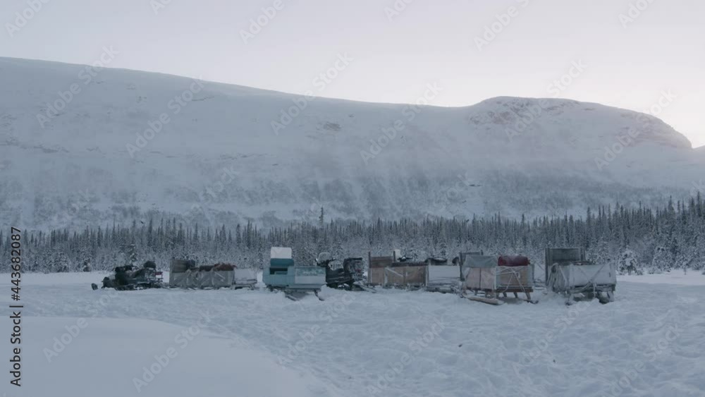 Parking on a snowy road of snowmobiles with a wooden sleigh attached to them for transporting tourists Parking on a snowy road of snowmobiles with a wooden sleigh attached to them for transporting tourists