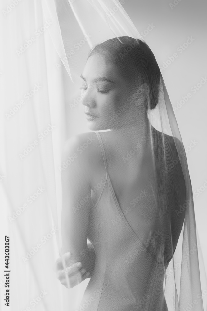 Fototapeta premium Beauty fashion portrait Attractive beautiful young asian woman close eyes Charming girl use curtain cover her body Young lady has beautiful body and has perfect shape She has beauty face Get relax