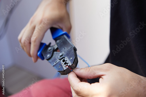 closeup man hands working with crimping tool and electrical cable photo