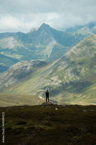Mountaineer hiking in the San Isidro pass, route of the Absent Lake, located between Asturias and Leon. In the background you can see the Picos de Europa in the Cantabrian Mountains. photo