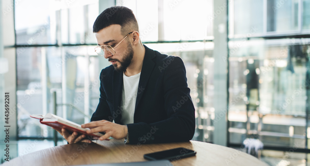 Fototapeta premium Serious man reading interesting book