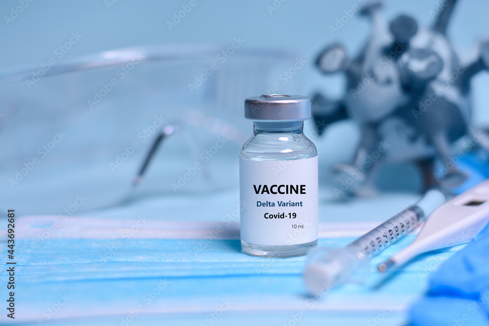 Two Bottle of Covid-19 vaccine to immunize from the Delta Variant Coronavirus, syringe , face mask,body thermometer and protective glasses on blue background.The concept of medicine, healthcare Two Bottle of Covid-19 vaccine to immunize from the Delta Variant Coronavirus, syringe , face mask,body thermometer and protective glasses on blue background.The concept of medicine, healthcare