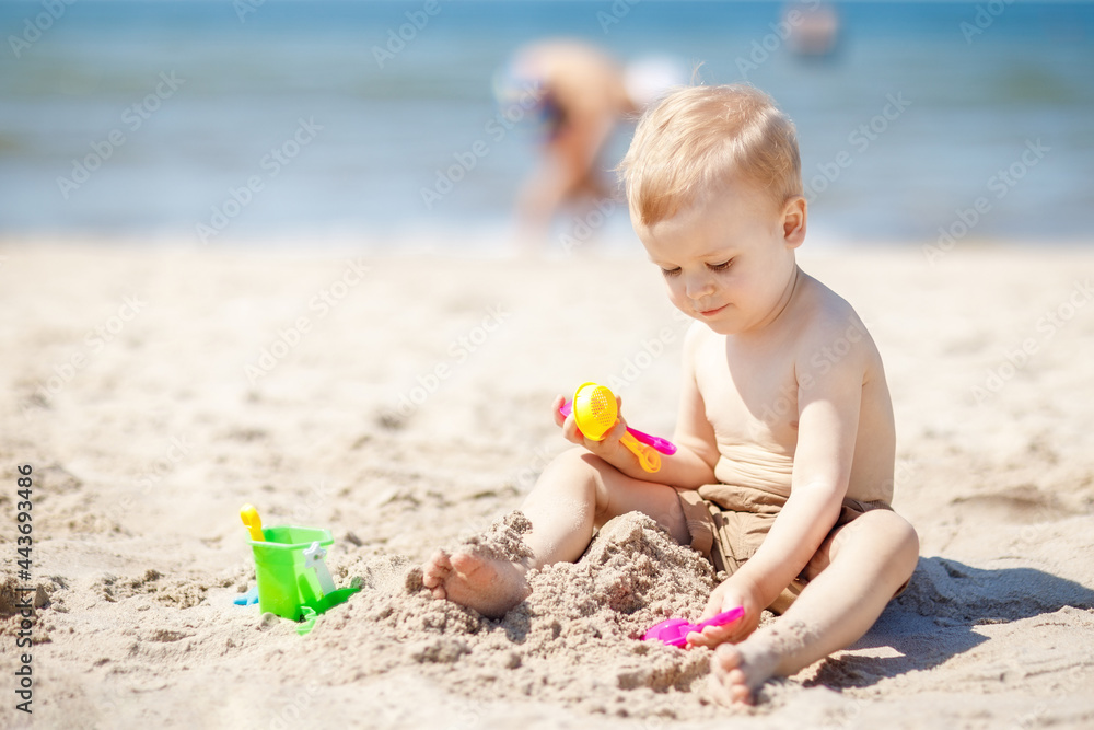 Little boy playing on the beach with sand beach toys Little boy playing on the beach with sand beach toys