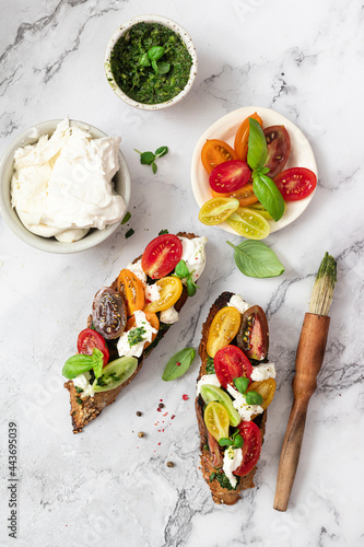 Bruschetta sandwiches with tomatoes,burrata cheese and pesto. Traditional  - grilled bruschetta toasts.