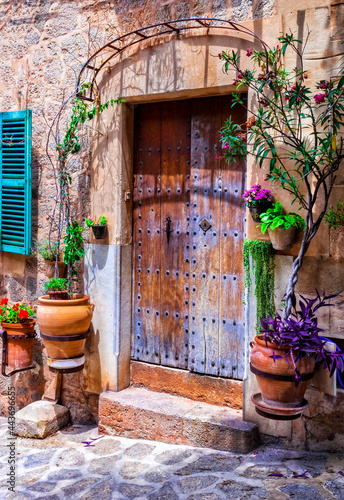 Fototapeta Naklejka Na Ścianę i Meble -  Charming floral streets with old doors and windows. Mediterranean culture and traditional villages