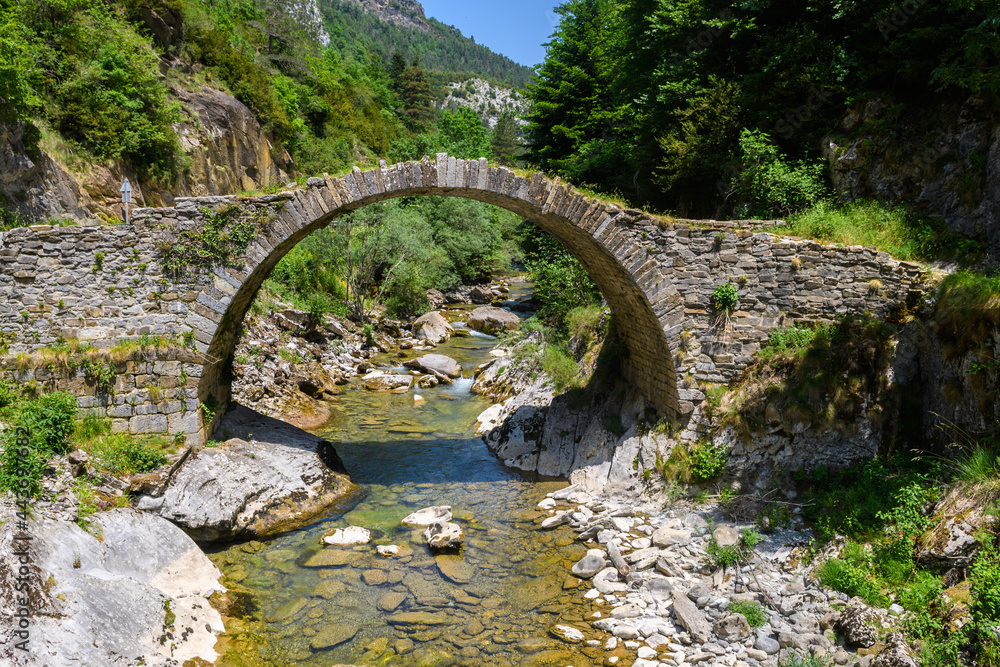 views of old roman bridge ruins crossed by a river in pyrenees, Spain views of old roman bridge ruins crossed by a river in pyrenees, Spain