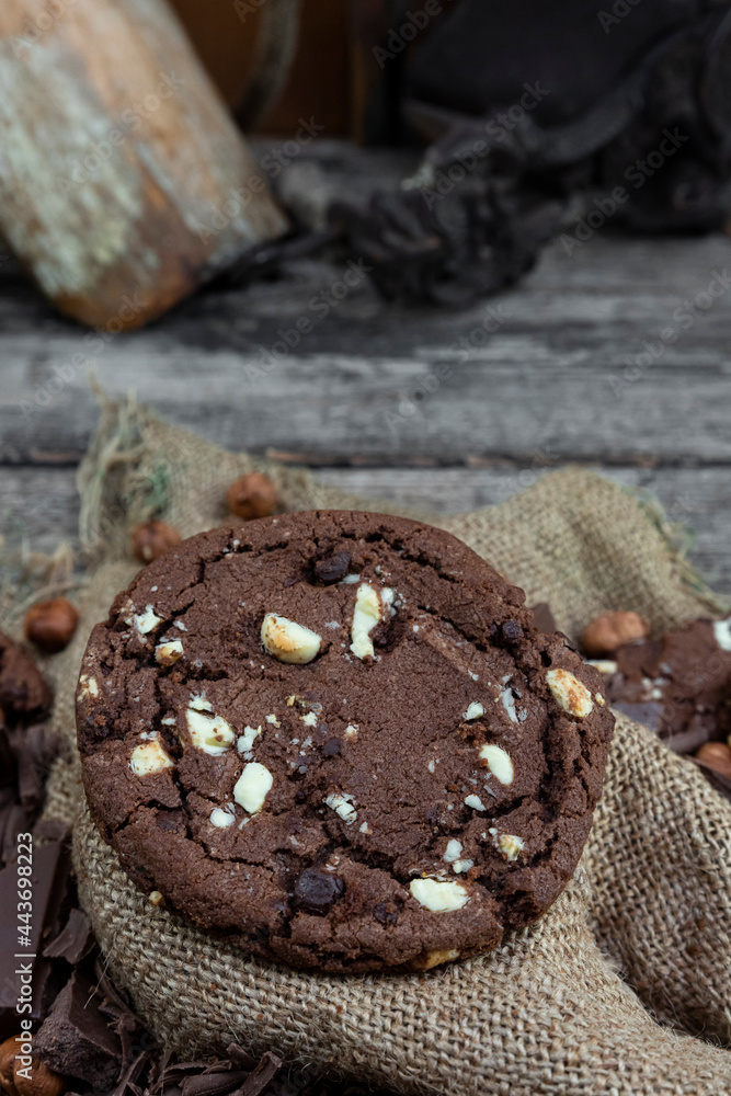 Chocolate cookies with hazelnuts , cocoa and pieces of dark chocolate on the rustic kitchen table Chocolate cookies with hazelnuts , cocoa and pieces of dark chocolate on the rustic kitchen table