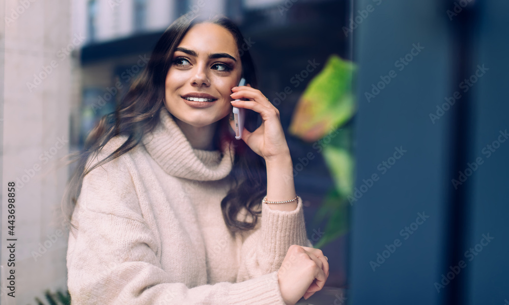 Smiling woman talking on smartphone in modern cafe Smiling woman talking on smartphone in modern cafe