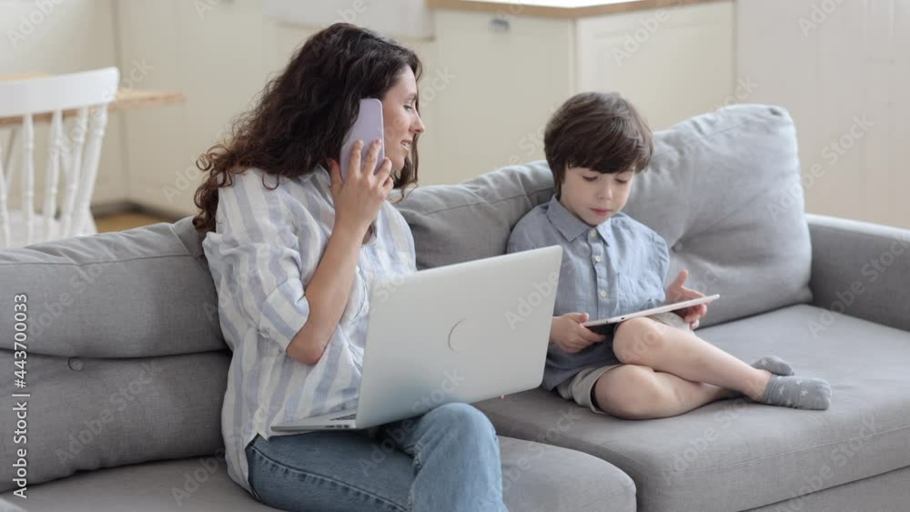 Successful multitasking businesswoman mother work from home communicate with partners on phone call and help preschool son with homeschool learning in digital tablet. Mom and remote worker lifestyle Successful multitasking businesswoman mother work from home communicate with partners on phone call and help preschool son with homeschool learning in digital tablet. Mom and remote worker lifestyle