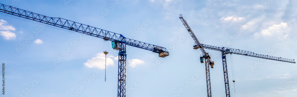 Banner of construction tower cranes with cabins in a blue sky. Industry concept Banner of construction tower cranes with cabins in a blue sky. Industry concept