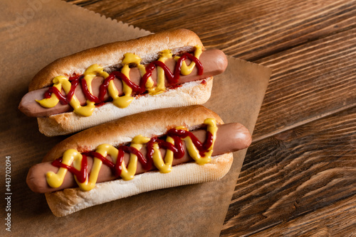 Canvas Print top view of delicious hot dogs and craft parchment on wooden surface