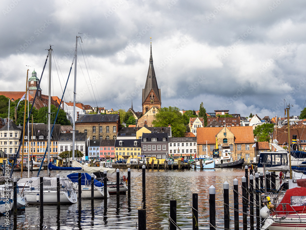 Obraz premium Sail boats in the port of Flensburg, St. Jorgen's Church in the background. Schleswig-Holstein in Germany