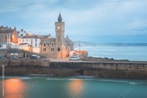 Moody, atmospheric night view of the pier and church clock tower at the quaint seaside village of Porthleven, Cornwall, England, UK. photo