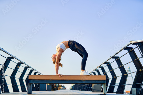 Pretty young woman doing yoga exercise on the nature in the morning.