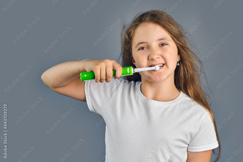 kid girl brushing her teeth with an electric toothbrush kid girl brushing her teeth with an electric toothbrush