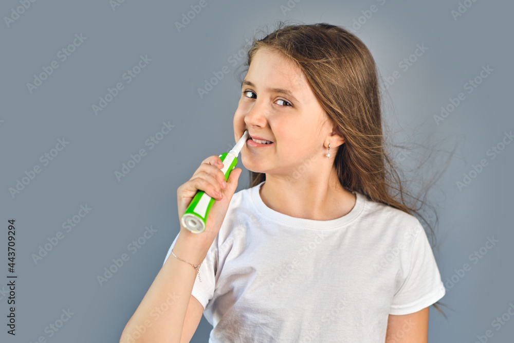kid girl brushing her teeth with an electric toothbrush kid girl brushing her teeth with an electric toothbrush