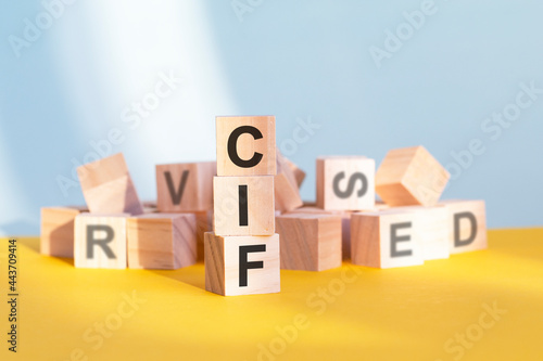 CIF written on wooden cubes, yellow background