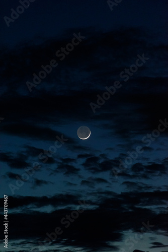 Crescent Moon in dark sky with clouds