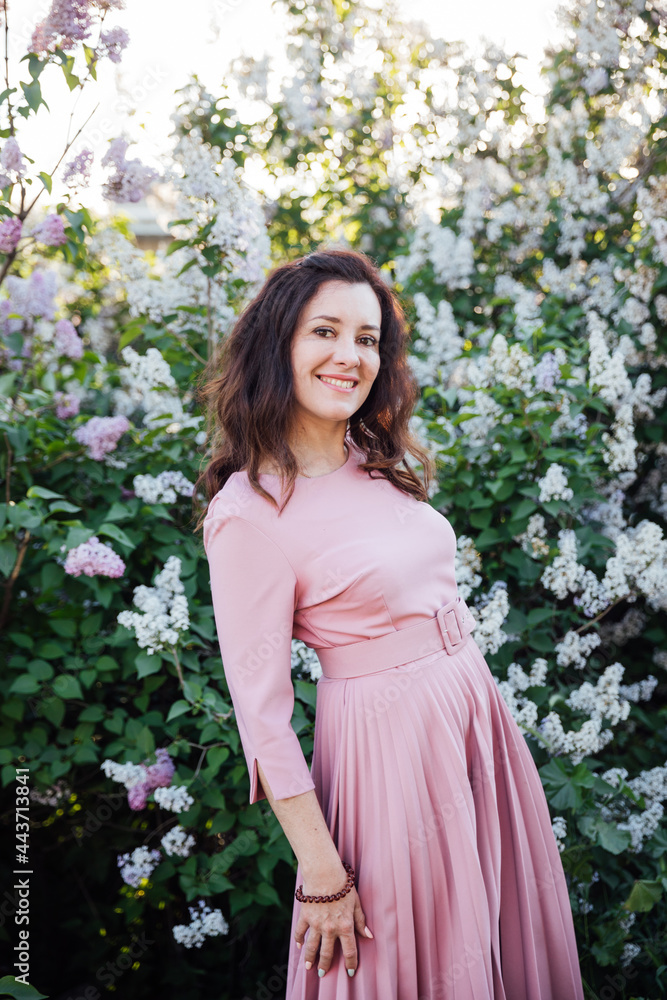 portrait of a beautiful brunette woman in a lilac dress with lilac flowers portrait of a beautiful brunette woman in a lilac dress with lilac flowers