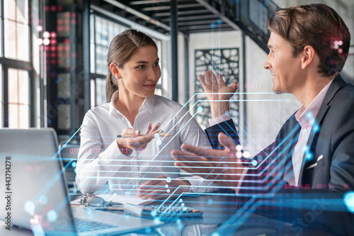 Businessman and businesswoman in formal wear working together to optimize business process by applying new technologies. Hi tech holograms over modern office background with panoramic windows