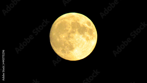 Full yellow moon on a black sky background