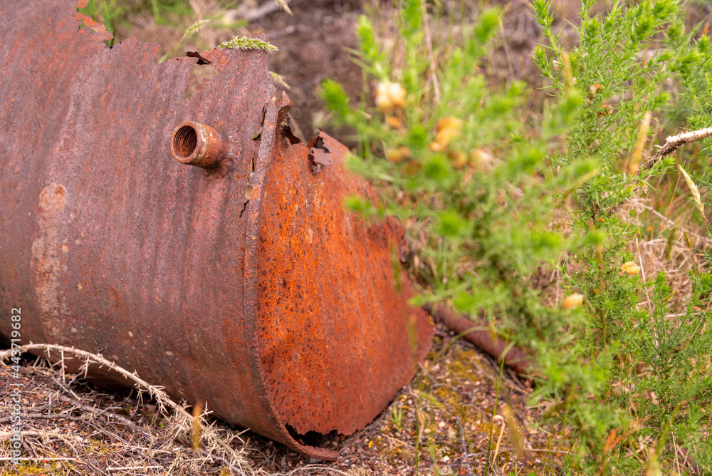Old barrels rusting over decades in the grass of Waiuta ghost town, New Zealand Old barrels rusting over decades in the grass of Waiuta ghost town, New Zealand