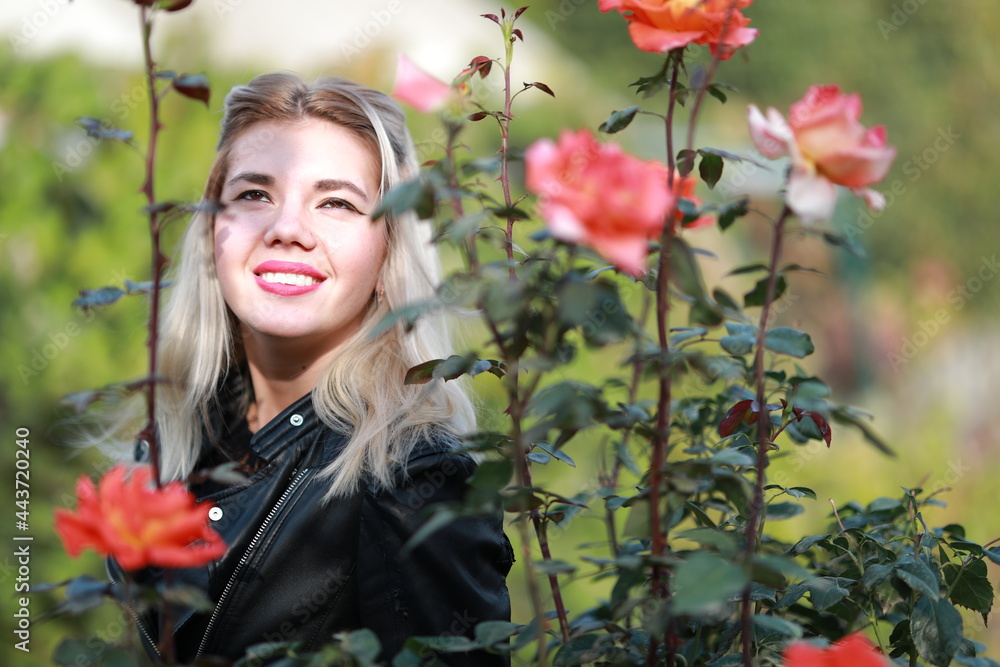 Naklejka premium portrait of a beautiful girl close-up in flowers in the garden