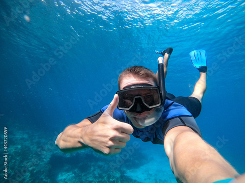 Man in snorkel mask doing selfie underwater. Vacation, freediving and travel concept. © Hladchenko Viktor
