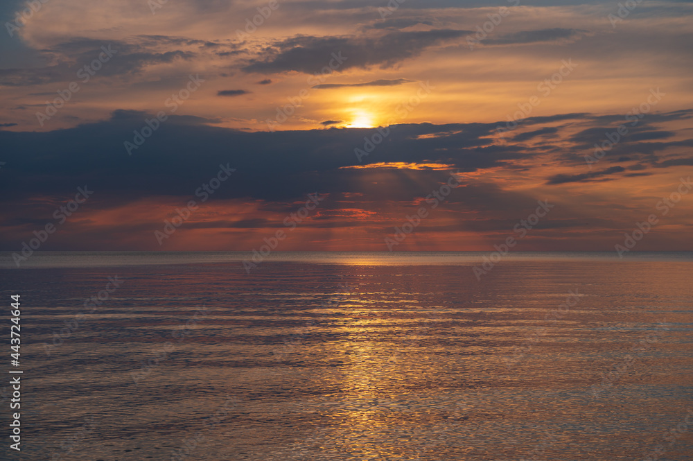 sunset in the sea with clouds and calm water sunset in the sea with clouds and calm water