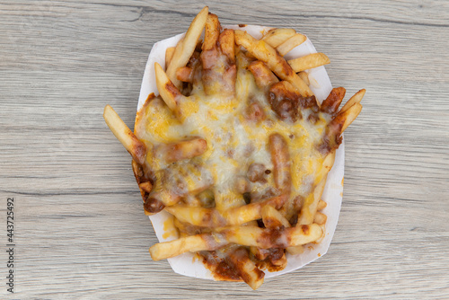 Foto Overhead view of melted cheese smothers this entire boat of chile cheese french fries as a very filling side dish