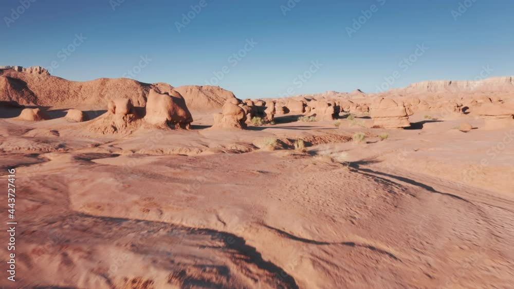 Drone flying above red hoodoo peaks in Goblin valley, nature park at sunrise Drone flying above red hoodoo peaks in Goblin valley, nature park at sunrise