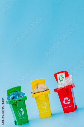 Wallpaper Mural Yellow, green and red recycle bins with recycle symbol on blue background. Keep city tidy, Leaves the recycling symbol. Nature protection concept Torontodigital.ca