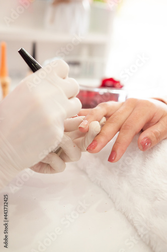 professional manicurist's hands painting nails with nail polish, vanity concept