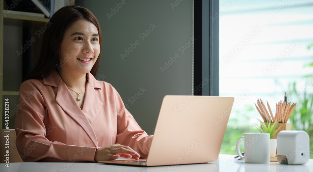 Portrait of happy young woman working on tablet pc while sitting at her working place in office. Portrait of happy young woman working on tablet pc while sitting at her working place in office.