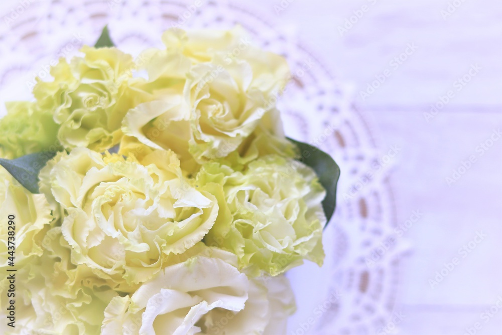 Obraz premium 白木の背景に黄色の花束のある女性的なテーブルフォト