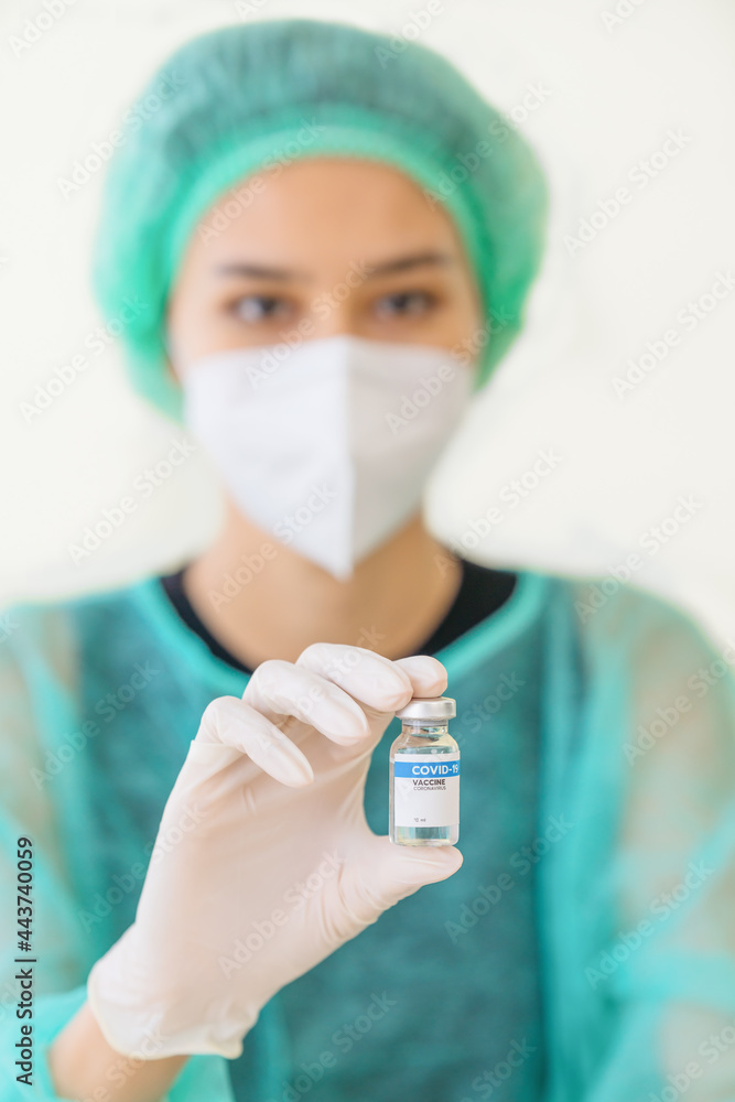 scientist or reseacher holding coronavirus covid-19 vaccine bottle