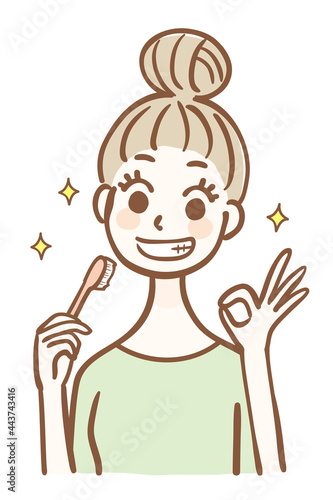 歯ブラシを持ってOKサインをする若い女性