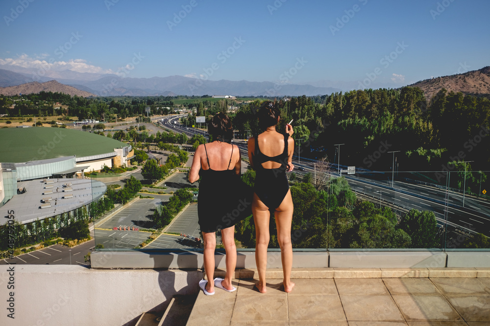 Two beautiful girls with black swimsuit and dress in front of a ...
