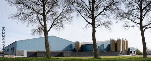 Photography Huge modern farm (a concentrated animal feeding operation) for fattening pigs in the Netherlands with a lot of feed silos in front of the building
