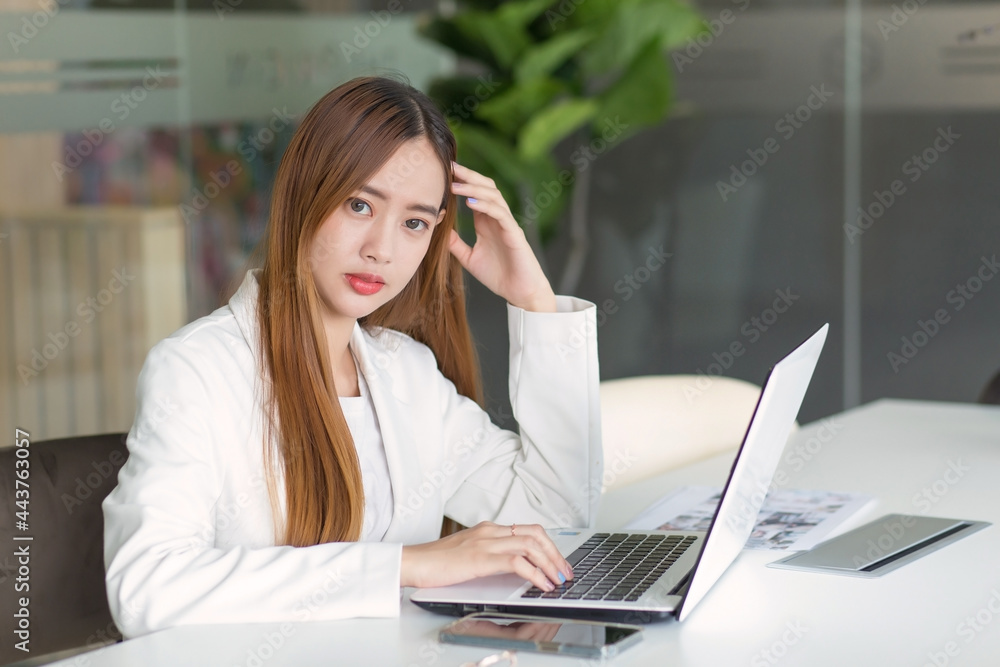 Asian business woman working in co-working space with laptop paper work (Business woman concept.) Asian business woman working in co-working space with laptop paper work (Business woman concept.)