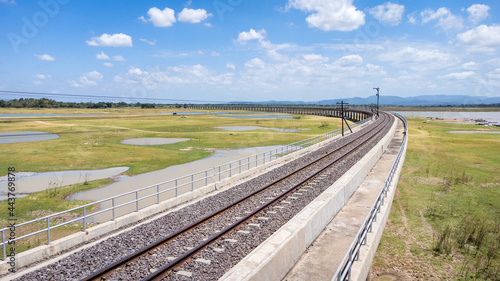 Aerial Unseen view of railroad tracks of floating Train bridge with white car in Khok Salung, Pa Sak Jolasid dam Lopburi amazing Thailand, Known as a floating train route.