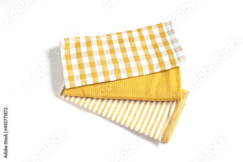 Top view new kitchen towels in yellow canary or dendelion,strip and white color simple pattern in differnet style on white background .Equipment necessary  in kithchen for wippe things. photo