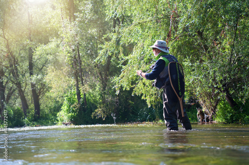 fly fisherman fishing in a small wild river