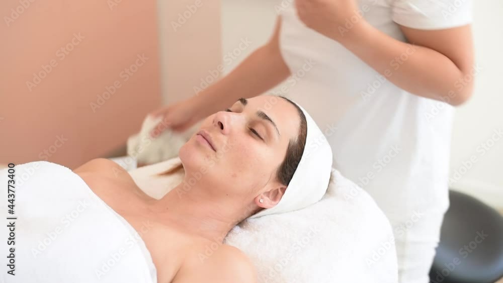 Cleaning skin by napkin on procedure of face. Skin care for beautiful woman receiving massage facial peeling. Beauty treatment in cosmetology spa salon Cleaning skin by napkin on procedure of face. Skin care for beautiful woman receiving massage facial peeling. Beauty treatment in cosmetology spa salon