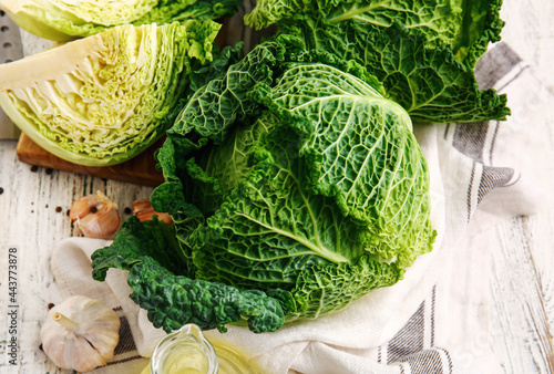 Fresh savoy cabbage on light wooden background, closeup photo
