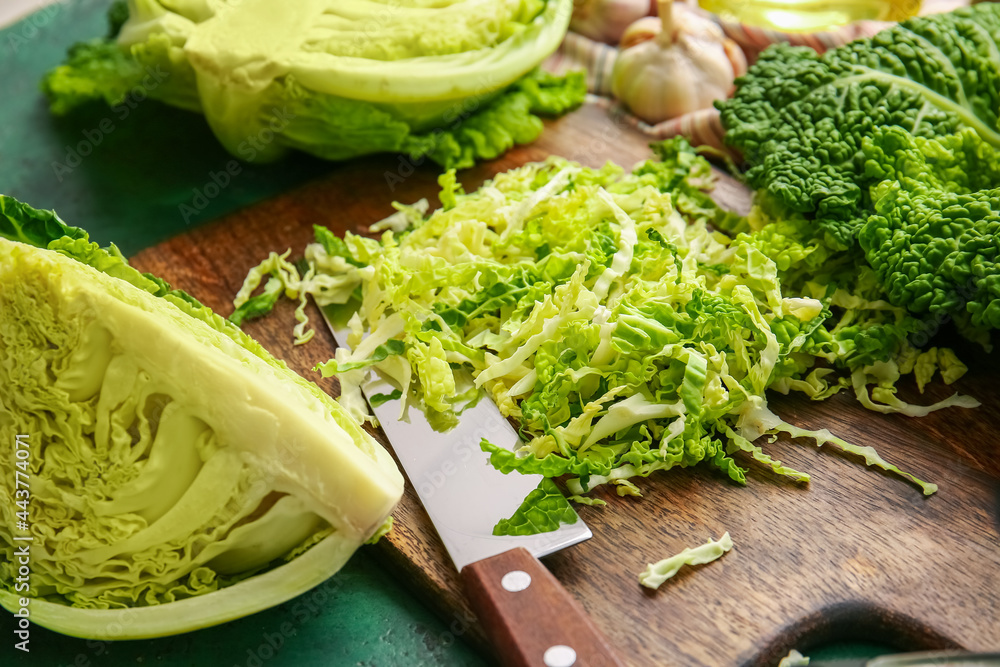 Board with heap of cut savoy cabbage on color background, closeup Board with heap of cut savoy cabbage on color background, closeup