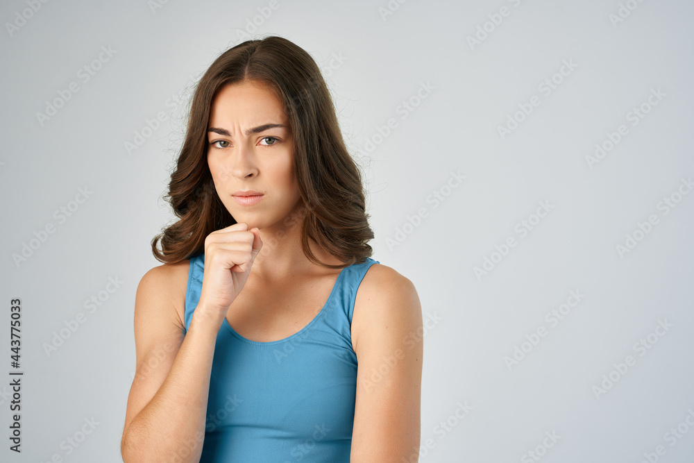 attractive brunette in a blue t-shirt with emotions fashionable hairstyle studio attractive brunette in a blue t-shirt with emotions fashionable hairstyle studio